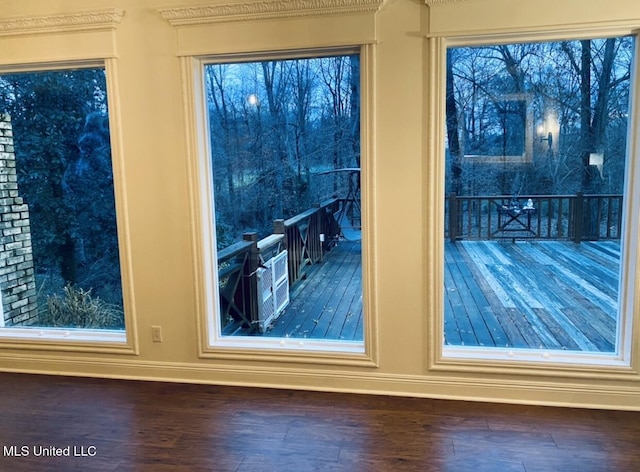 doorway to outside featuring baseboards and wood finished floors