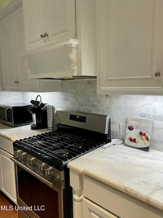 kitchen featuring appliances with stainless steel finishes, backsplash, and white cabinetry