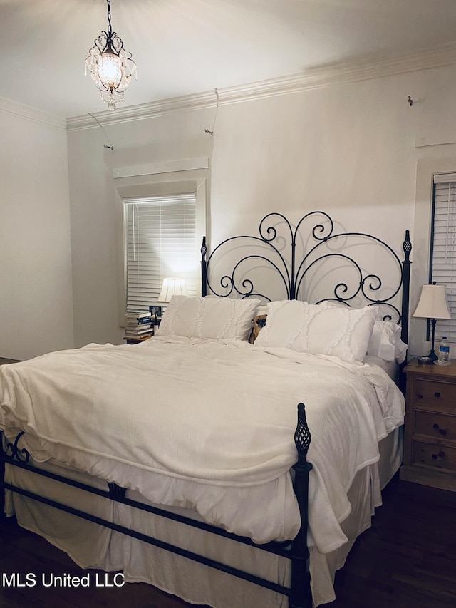 bedroom with wood finished floors and crown molding