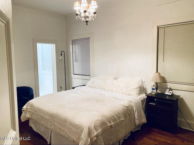 bedroom with ornamental molding, dark wood finished floors, and a notable chandelier