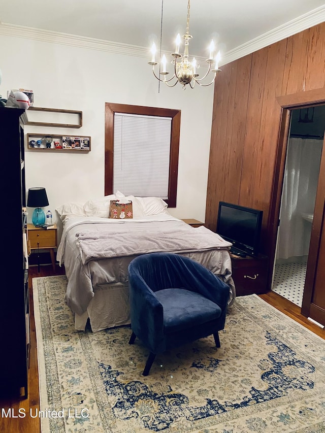 bedroom with a chandelier, wood finished floors, and crown molding