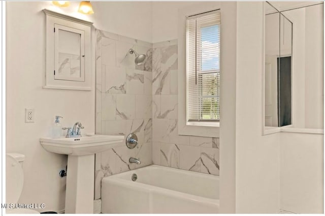 full bathroom featuring a sink, bathing tub / shower combination, and toilet