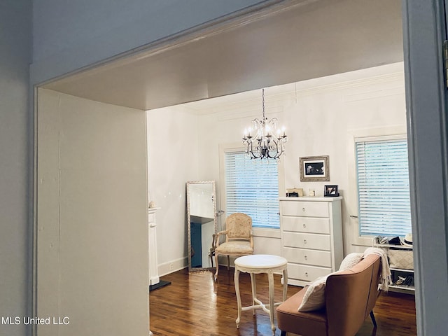 sitting room featuring dark wood-style floors, baseboards, a chandelier, and ornamental molding