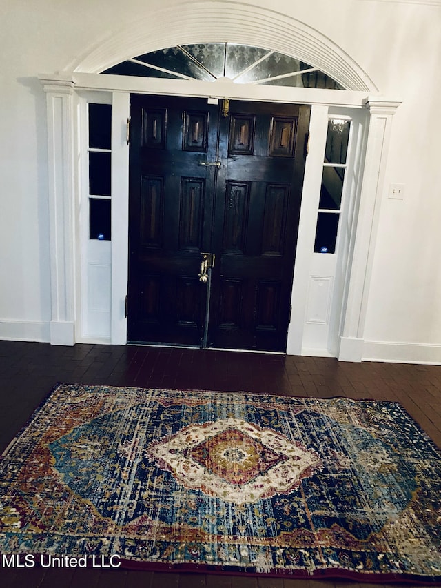 entryway with decorative columns, hardwood / wood-style flooring, and baseboards