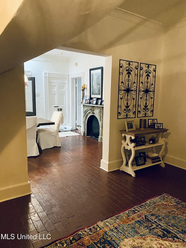 hall featuring ornamental molding, brick floor, and baseboards