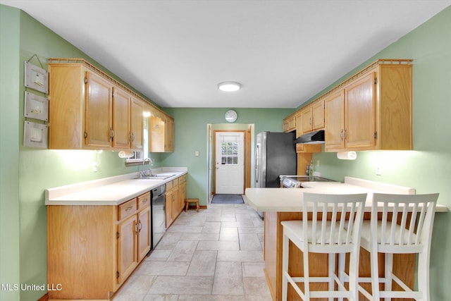 8809 Old Walnut Rd, Ocean Springs, MS 39564 - kitchen featuring black dishwasher, freestanding refrigerator, under cabinet range hood, stone tile flooring, and a sink