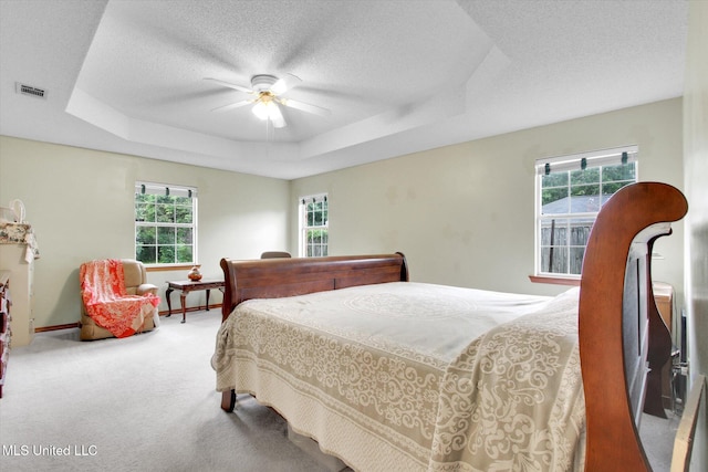 8809 Old Walnut Rd, Ocean Springs, MS 39564 - bedroom with multiple windows, carpet flooring, a raised ceiling, ceiling fan, and a textured ceiling