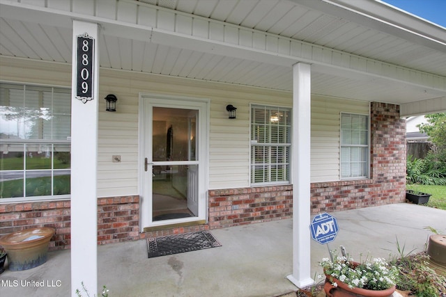 8809 Old Walnut Rd, Ocean Springs, MS 39564 - doorway to property with brick siding and a porch