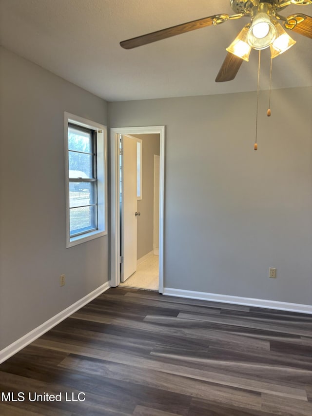 empty room featuring dark hardwood / wood-style flooring and ceiling fan