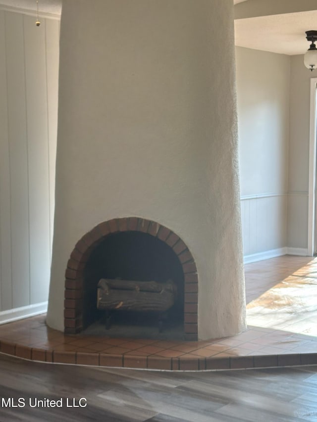 interior details with hardwood / wood-style floors and a tiled fireplace