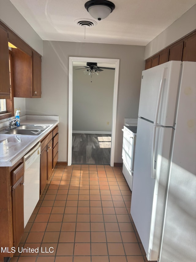 kitchen with dark tile patterned flooring, ceiling fan, white appliances, and sink