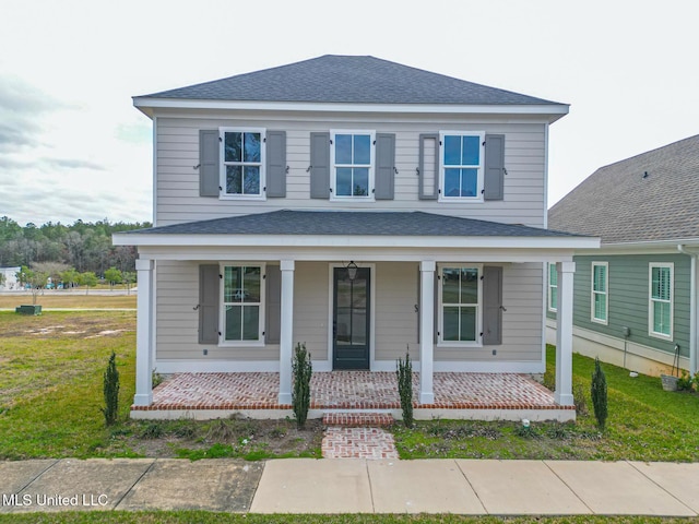 view of front of house featuring a porch, a shingled roof, and a front lawn