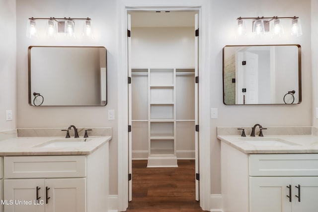 bathroom with two vanities, a sink, and wood finished floors