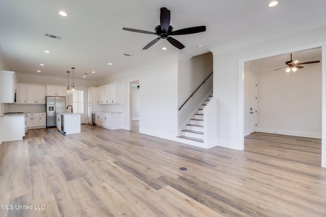 unfurnished living room with light wood-style flooring, stairs, visible vents, and recessed lighting