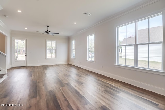 unfurnished living room with ornamental molding, dark wood-type flooring, visible vents, and baseboards