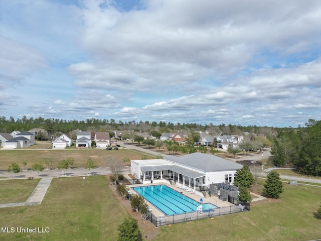 pool featuring a patio, a lawn, a fenced backyard, and a residential view