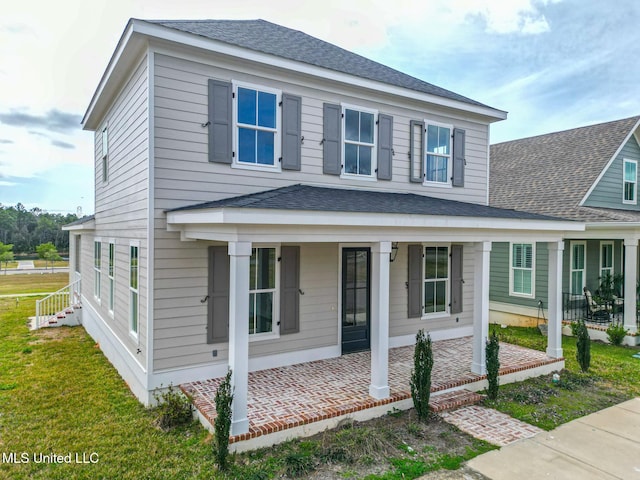 view of front of home with a front yard, a porch, and roof with shingles