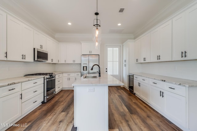 kitchen with dark wood-style flooring, ornamental molding, stainless steel appliances, and a sink