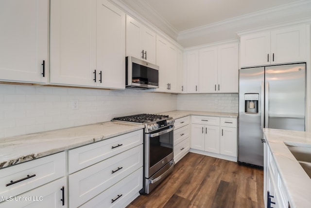 kitchen featuring appliances with stainless steel finishes, dark wood finished floors, white cabinetry, and ornamental molding