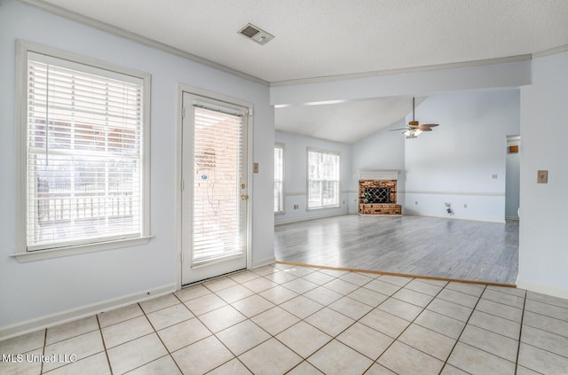 interior space featuring light tile patterned floors, vaulted ceiling, and ceiling fan