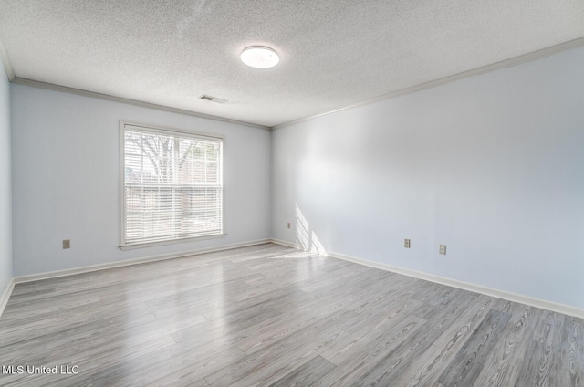 empty room featuring ornamental molding, a textured ceiling, and light wood-type flooring