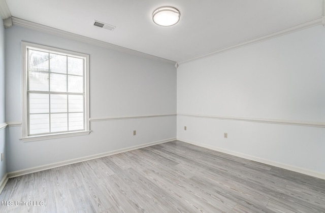 empty room featuring light hardwood / wood-style flooring and ornamental molding