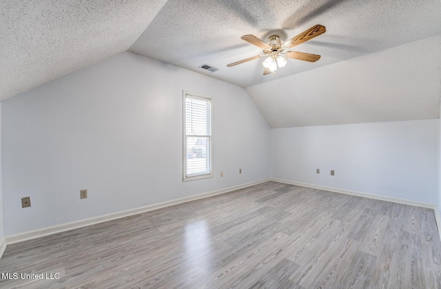 additional living space featuring ceiling fan, light hardwood / wood-style flooring, and vaulted ceiling