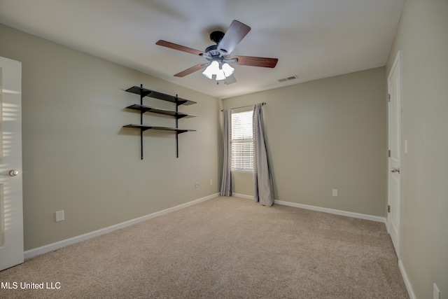 carpeted spare room featuring ceiling fan