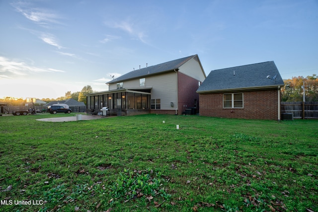 back of house with cooling unit, a lawn, a patio area, and a sunroom