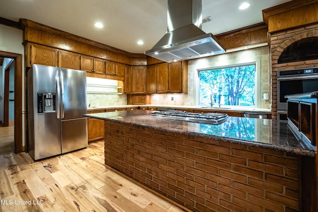 6147 Wirtz Rd, Flowood, MS 39232 - kitchen with stainless steel appliances, island range hood, light wood-type flooring, brown cabinets, and recessed lighting