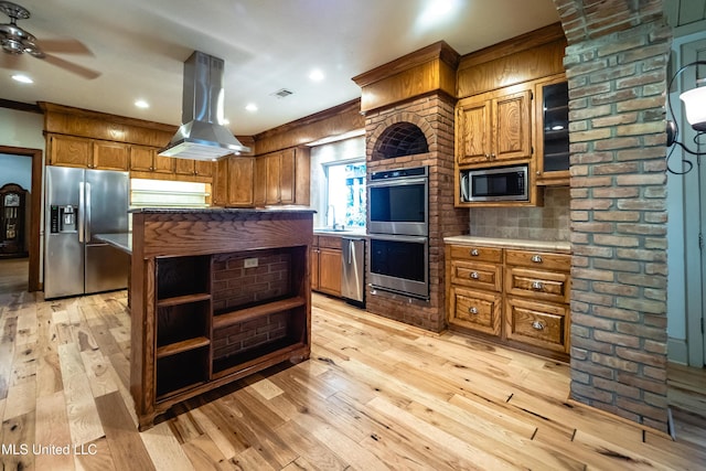 6147 Wirtz Rd, Flowood, MS 39232 - kitchen with appliances with stainless steel finishes, island exhaust hood, light wood finished floors, brown cabinets, and crown molding