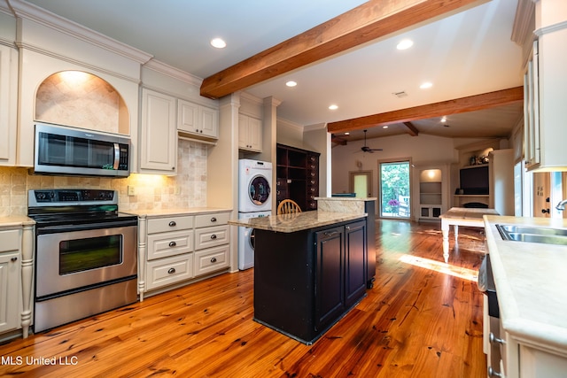 6147 Wirtz Rd, Flowood, MS 39232 - kitchen featuring appliances with stainless steel finishes, beam ceiling, backsplash, light wood-type flooring, and open floor plan