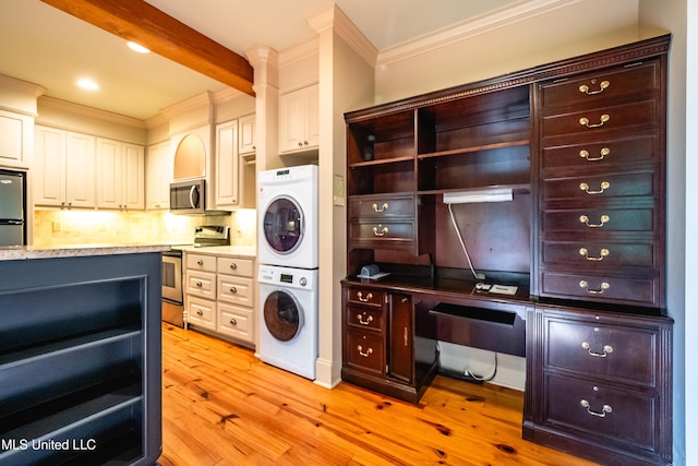 6147 Wirtz Rd, Flowood, MS 39232 - kitchen featuring appliances with stainless steel finishes, stacked washer / dryer, ornamental molding, backsplash, and light wood-style flooring