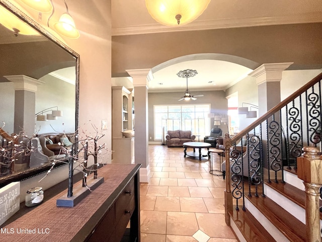 tiled foyer entrance featuring ceiling fan, ornate columns, and crown molding