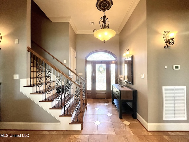 entrance foyer featuring light tile patterned flooring and crown molding