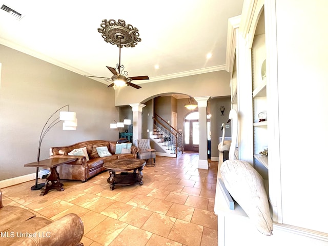 living room with decorative columns, crown molding, and ceiling fan