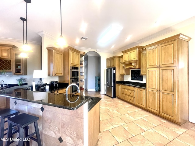 kitchen featuring decorative light fixtures, kitchen peninsula, a breakfast bar, and appliances with stainless steel finishes