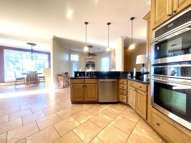 kitchen featuring ceiling fan with notable chandelier, sink, crown molding, appliances with stainless steel finishes, and decorative light fixtures