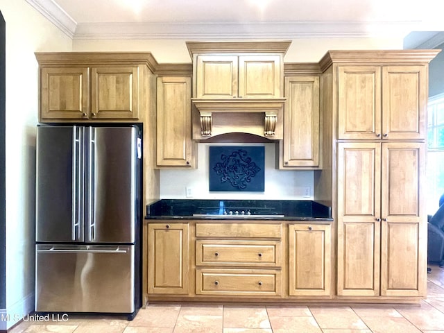 kitchen featuring custom exhaust hood, crown molding, dark stone countertops, cooktop, and stainless steel refrigerator