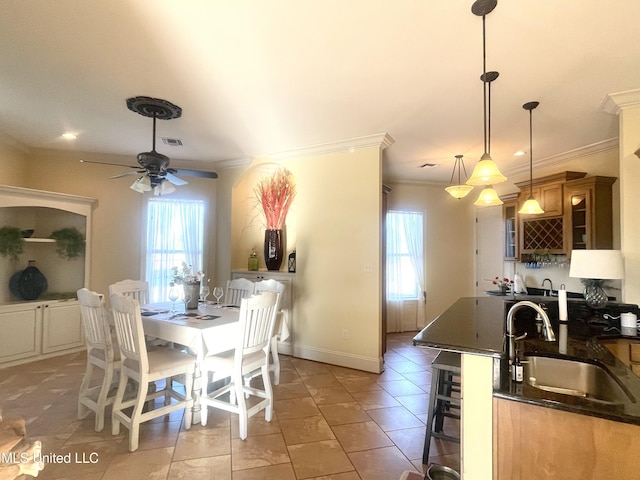 tiled dining room featuring ceiling fan, indoor wet bar, and ornamental molding