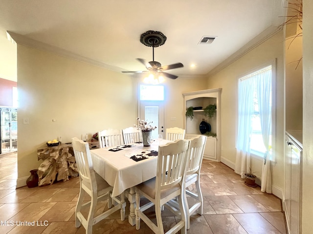 dining space with crown molding and ceiling fan