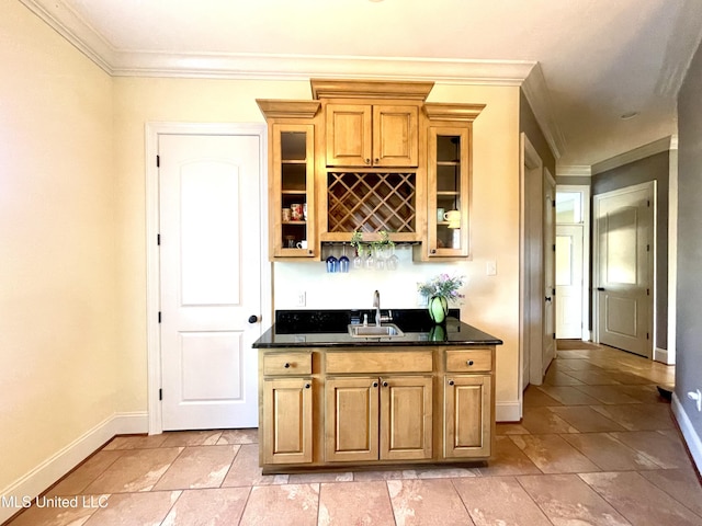 bar with dark stone countertops, crown molding, and sink