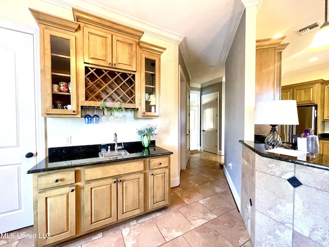 bar featuring stainless steel refrigerator, crown molding, sink, and dark stone countertops