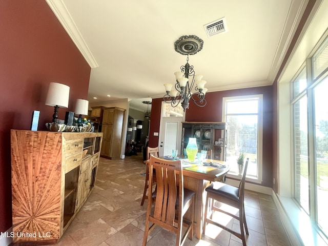 dining space featuring ornamental molding and a notable chandelier