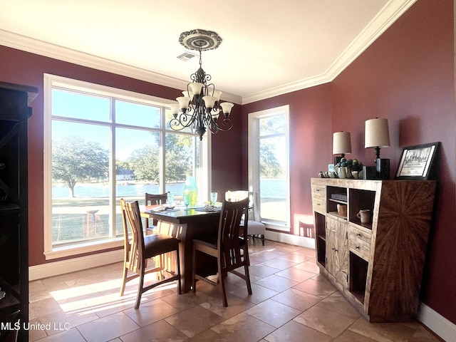 tiled dining area featuring a water view, an inviting chandelier, a healthy amount of sunlight, and crown molding