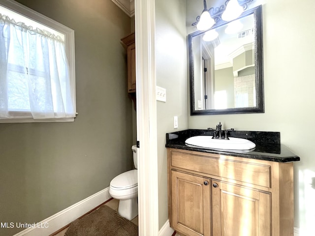 bathroom with vanity, toilet, and crown molding