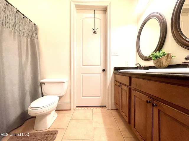 bathroom featuring tile patterned flooring, vanity, and toilet