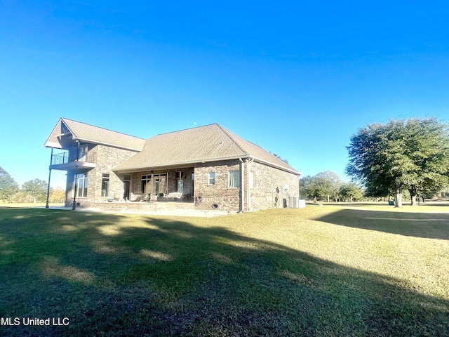 back of property with a balcony and a yard