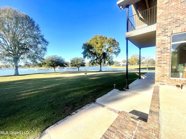 view of yard with a water view and a balcony