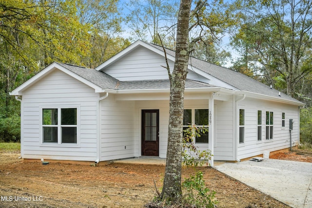 view of front of home with a patio area and a shingled roof